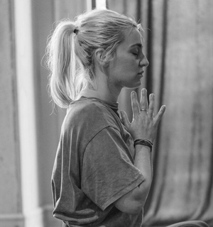 Side headshot of Georgina sitting in prayer