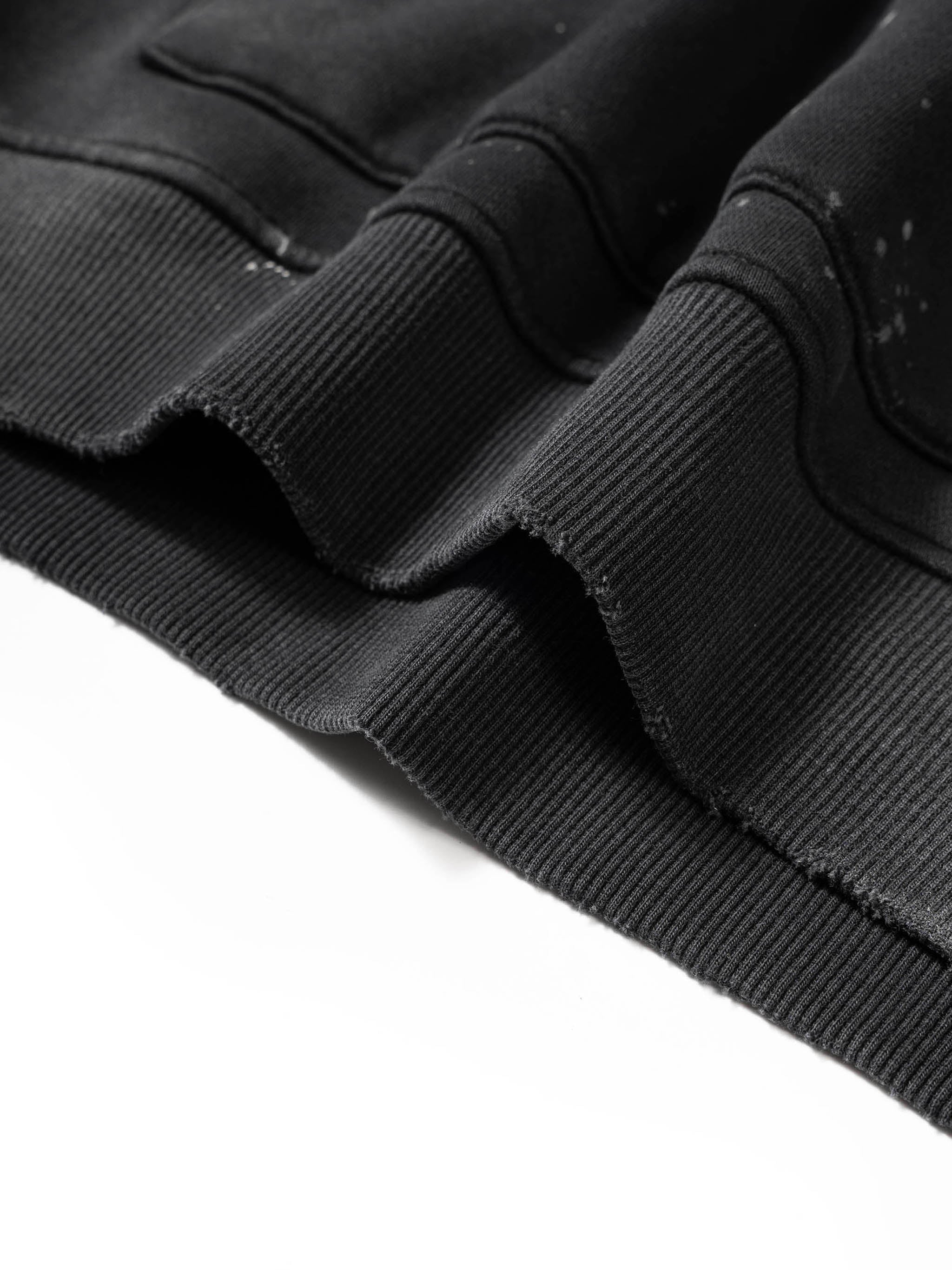 Close-up of a black jacket with frayed edges on a white background