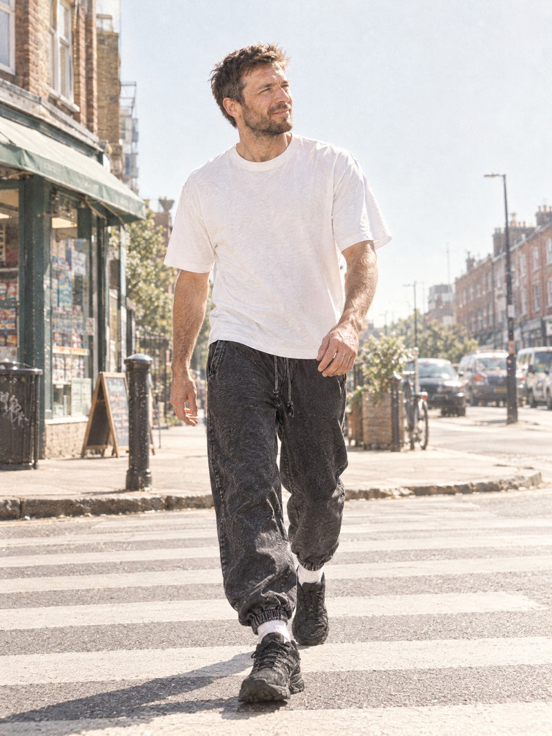 Man wearing the Men's Snow Wash Heavyweight Joggers in washed Black with a white t-shirt
